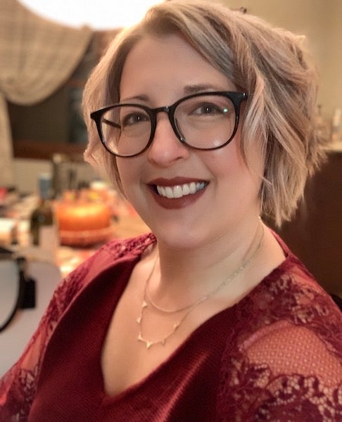 headshot of Trisha, white woman with short blonde hair and dark glasses